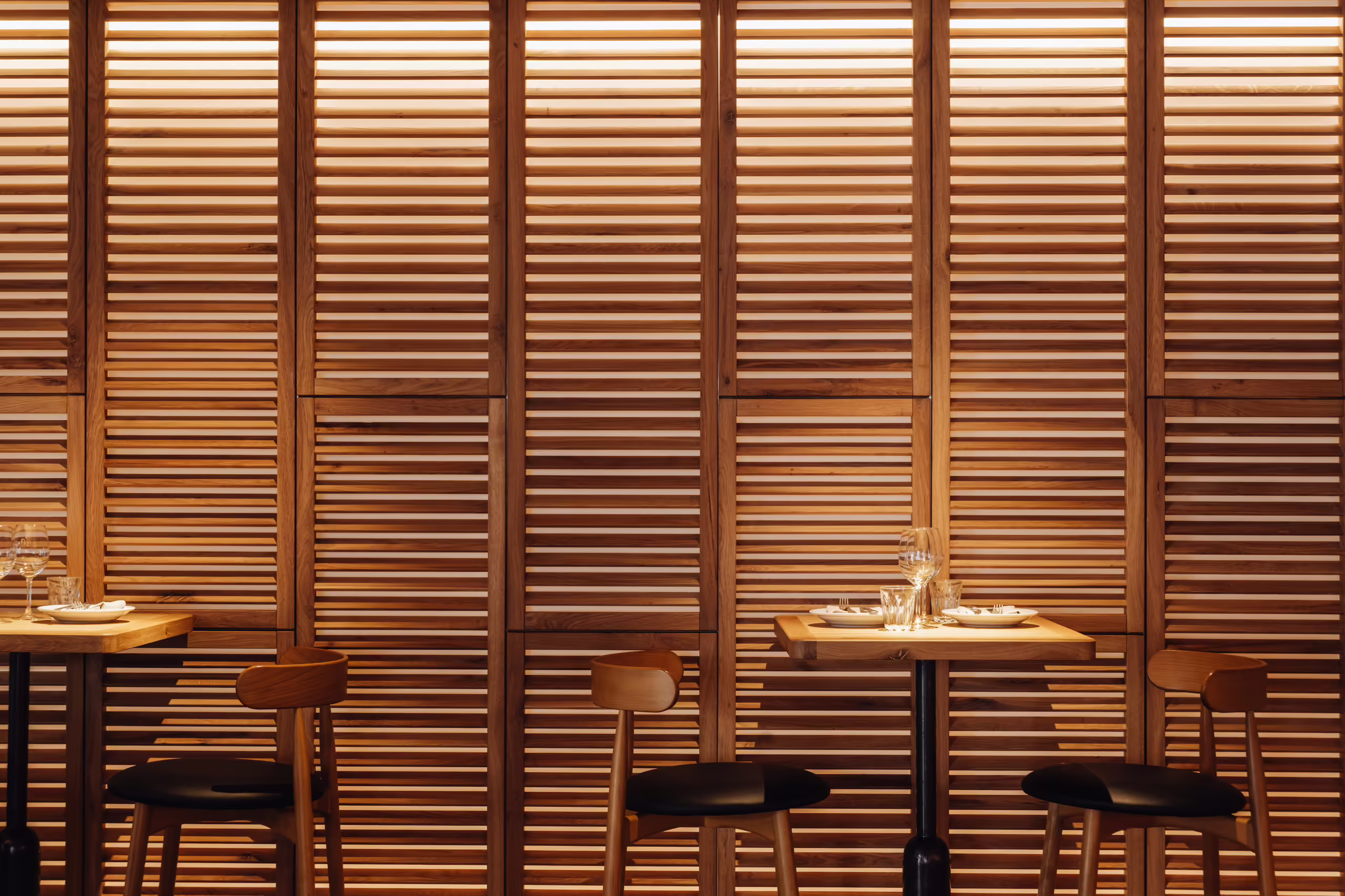 Long counter and dining tables under the lighting rig in the NENI Amsterdam interior