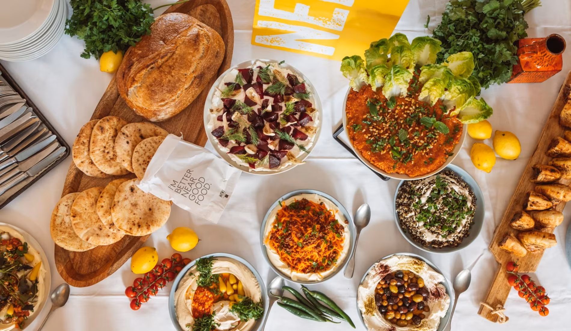 Overhead spread of bread, dips and salads for catering