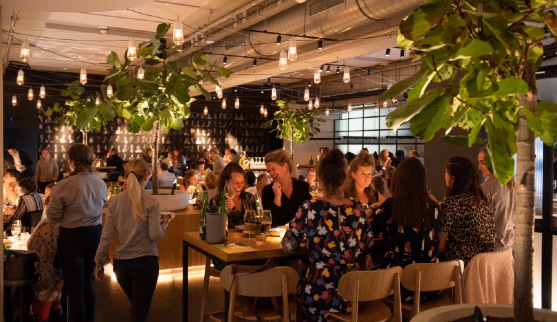 Guests standing around long tables in the daylit dining room