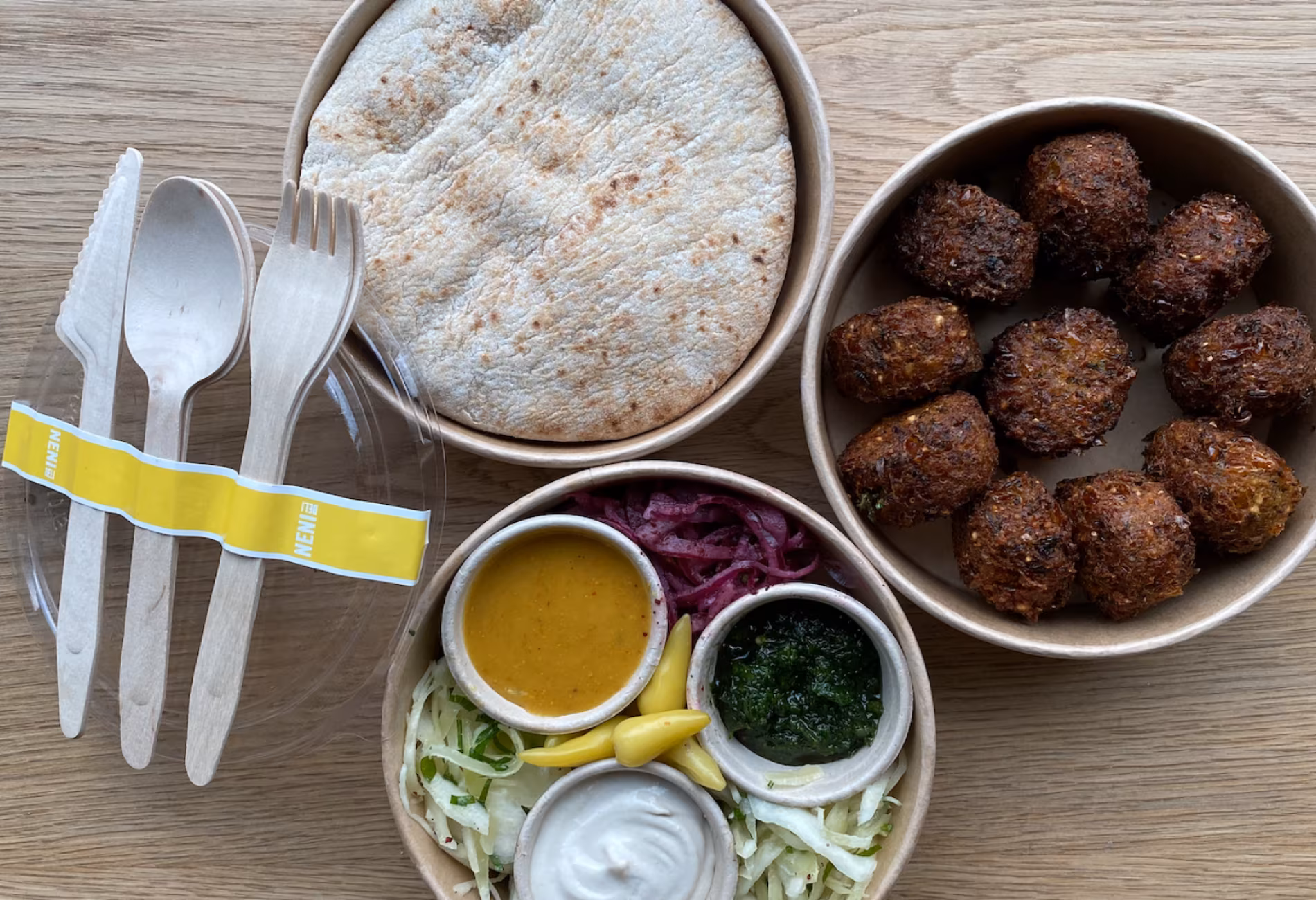 Takeaway platter with pita, falafel, dips and salad seen from above