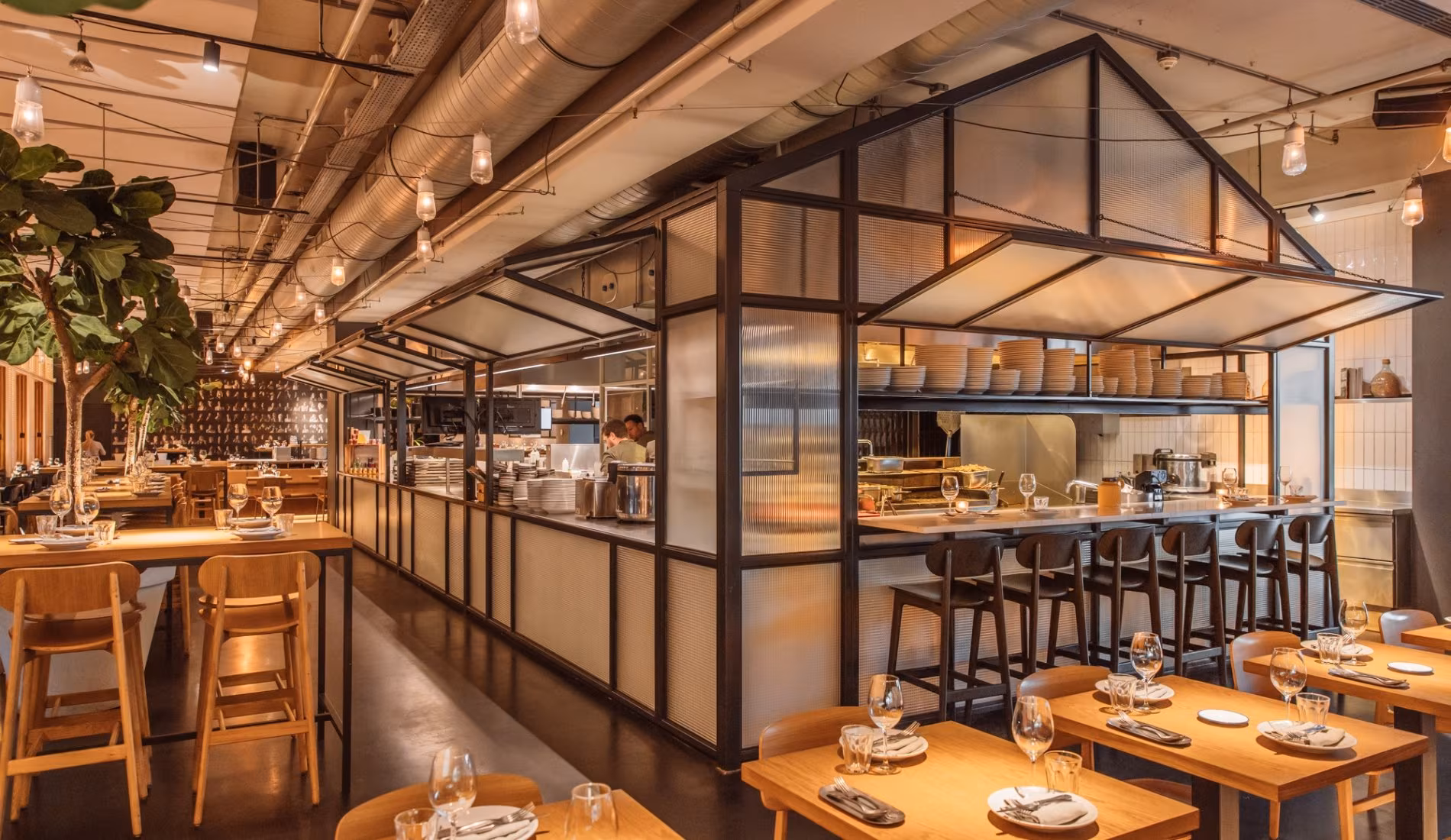 The glass-enclosed open kitchen seen across the dining room