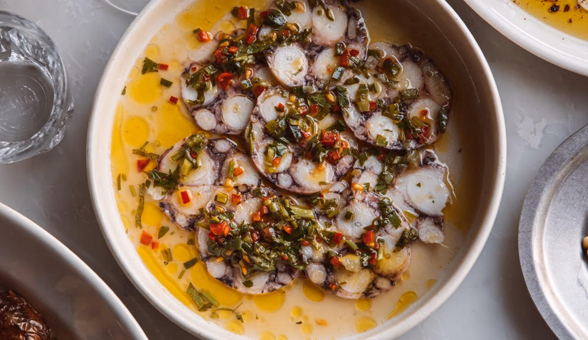 Bowl of marinated octopus with herbs and chilli in olive oil