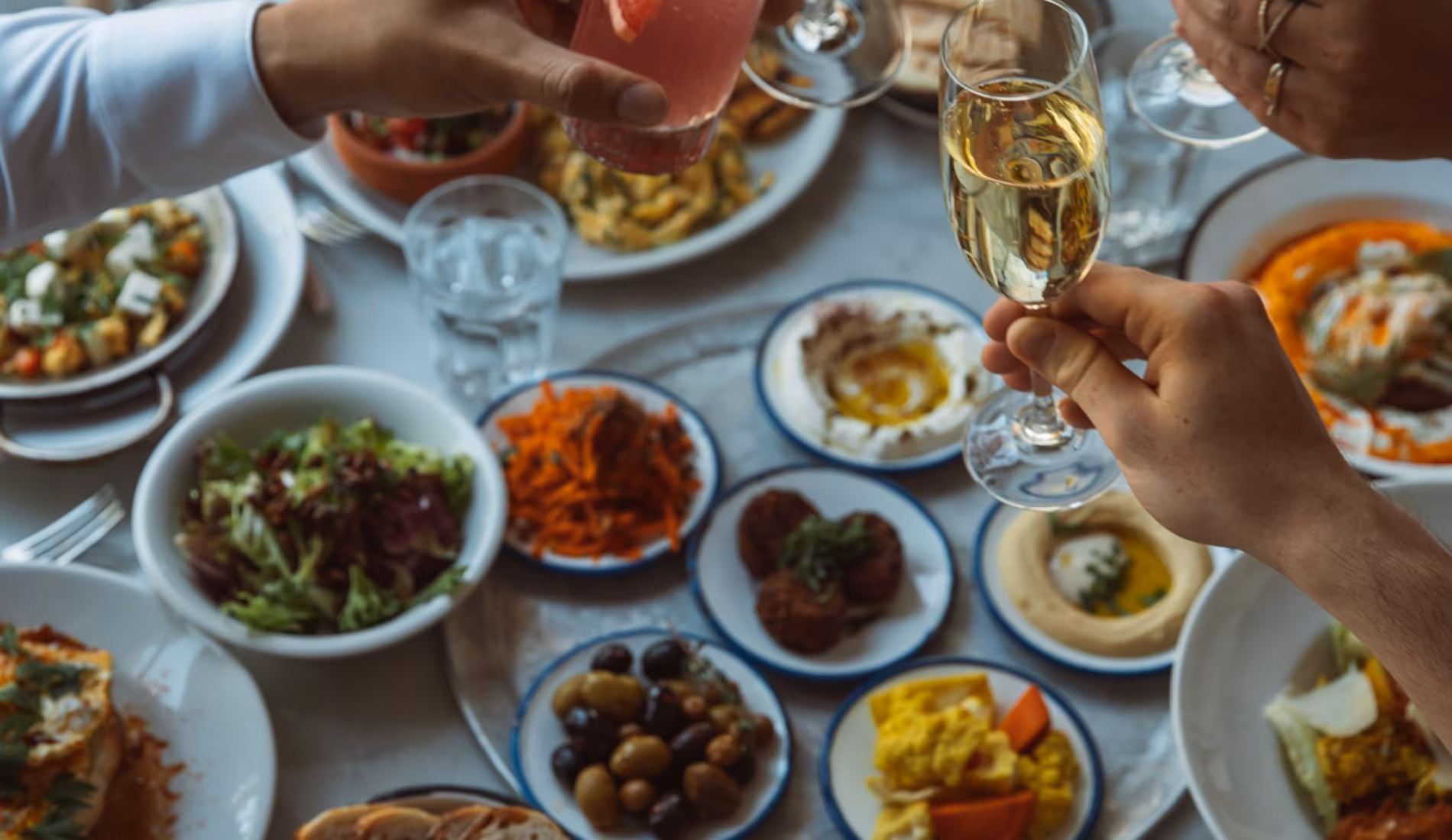 Table full of brunch dishes with hands reaching in