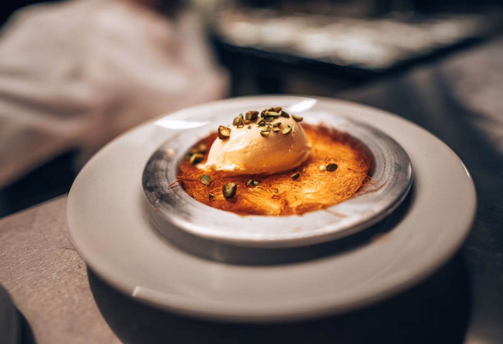 Close-up of a baked dessert with a quenelle of cream on a ceramic plate