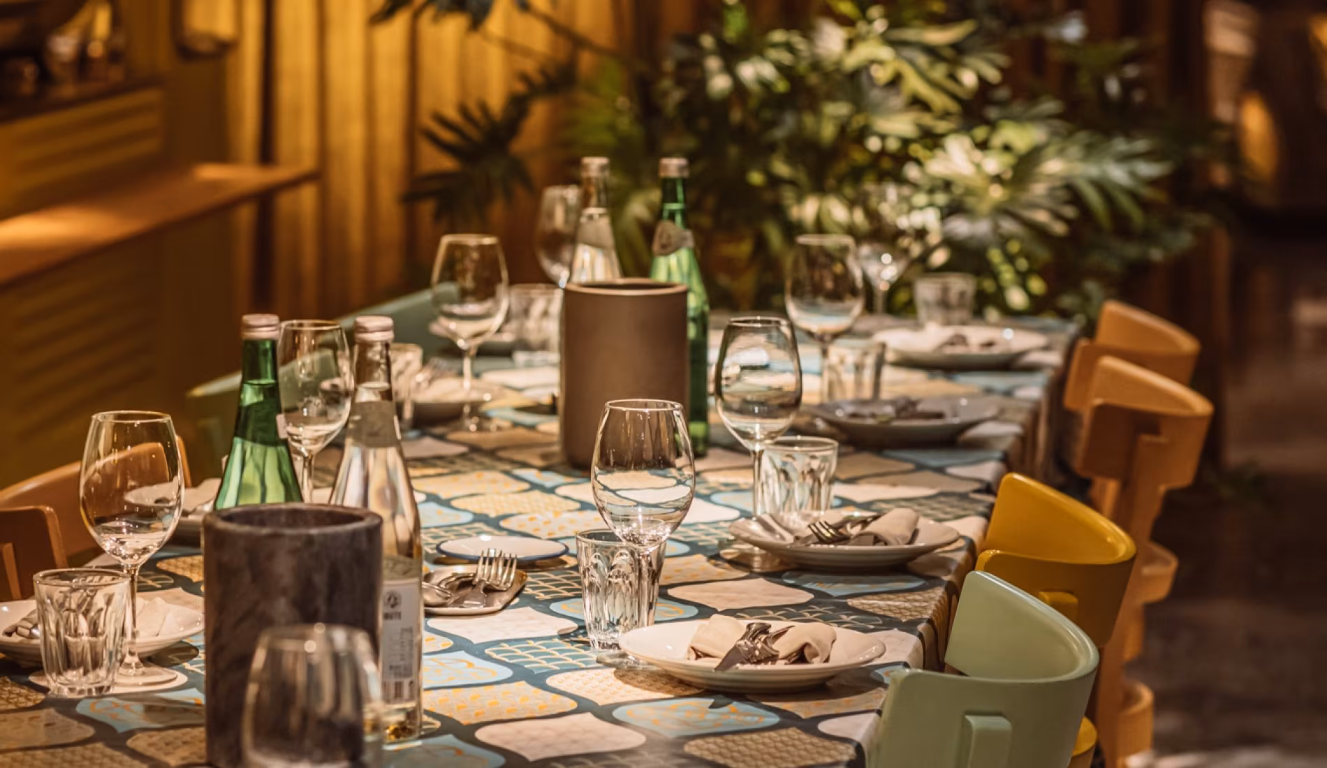 Intimate private dining table set with candles and green chairs