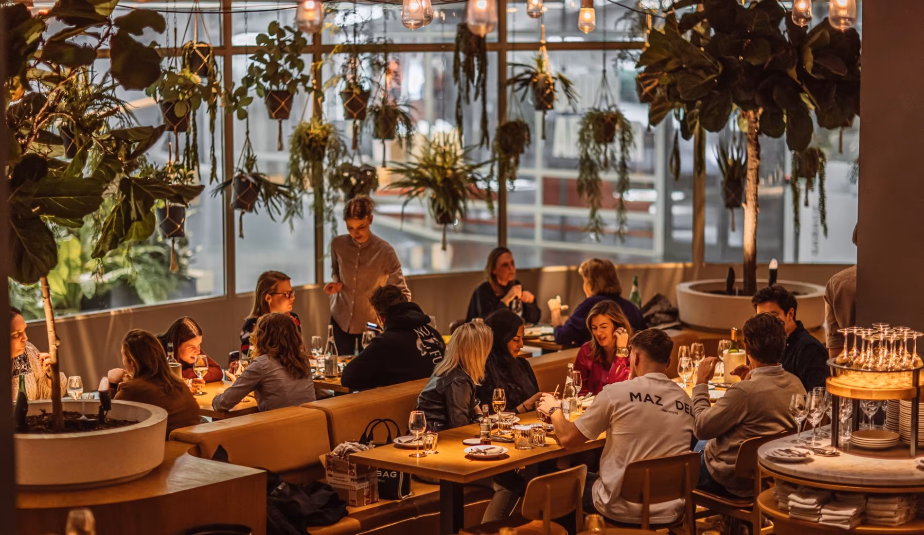 Guests seated at long tables in the split-level dining room