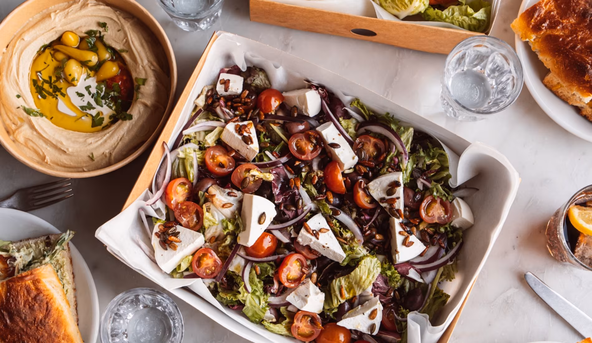 Platters of salad with feta and tomatoes on a set table